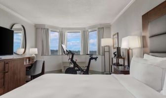 Day use room with work desk and Peloton bike at Hilton Crystal City At Washington Reagan National Airport.