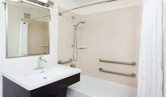 Private guest bathroom with combined shower and tub at Sonesta Simply Suites Dallas Las Colinas.