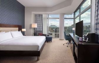 Bright king room with work station and a view of the city at Hilton Garden Inn Washington DC/Georgetown Area.
