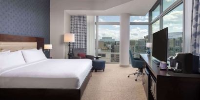 Bright king room with work station and a view of the city at Hilton Garden Inn Washington DC/Georgetown Area.
