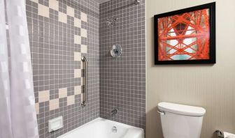 Guest bathroom with shower and tub at Embassy Suites By Hilton San Francisco Airport Waterfront.