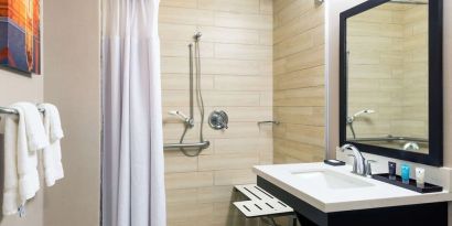 Accessible private guest bathroom with shower at Sonesta Atlanta Airport North.