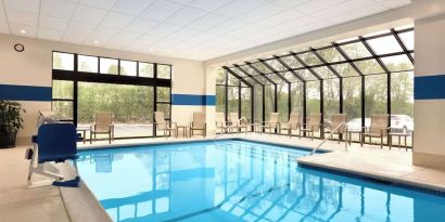Indoor pool with lounge chairs at DoubleTree By Hilton Hartford - Bradley Airport.