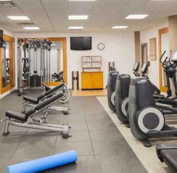 Fitness center with treadmill, exercising bike and weights at the DoubleTree by Hilton Orlando Downtown.