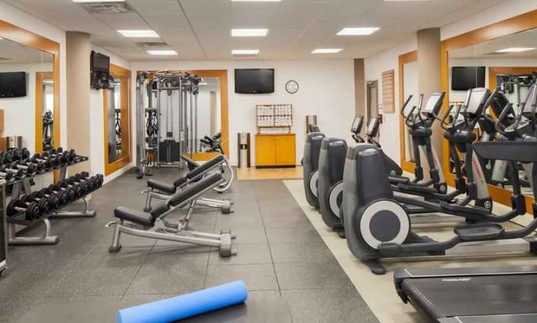 Fitness center with treadmill, exercising bike and weights at the DoubleTree by Hilton Orlando Downtown.