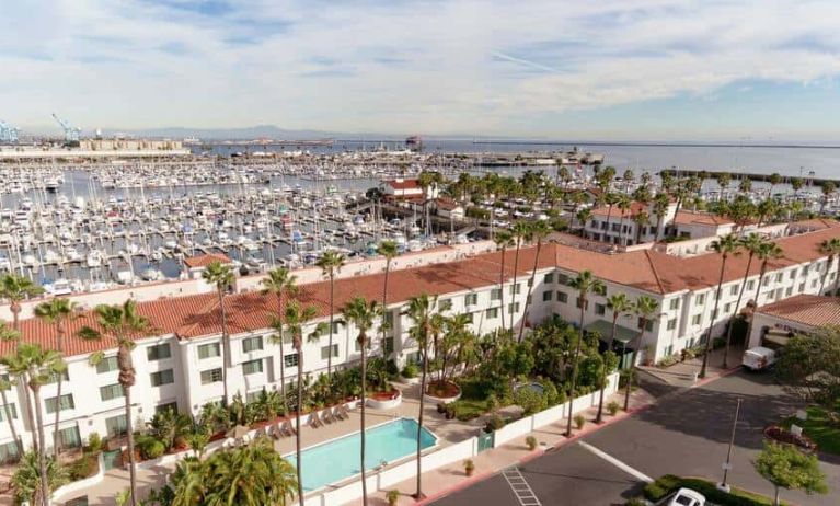 Aerial view of San Pedro Hilton Double Tree and the marina filled with boats behind it.