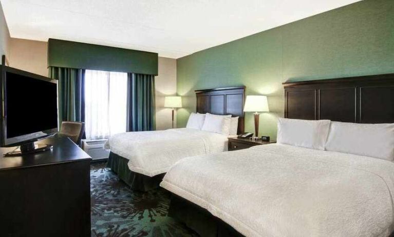 Specious room with 2 size queen beds, TV and window view at the Hampton Inn by Hilton Toronto Airport Corporate Centre.