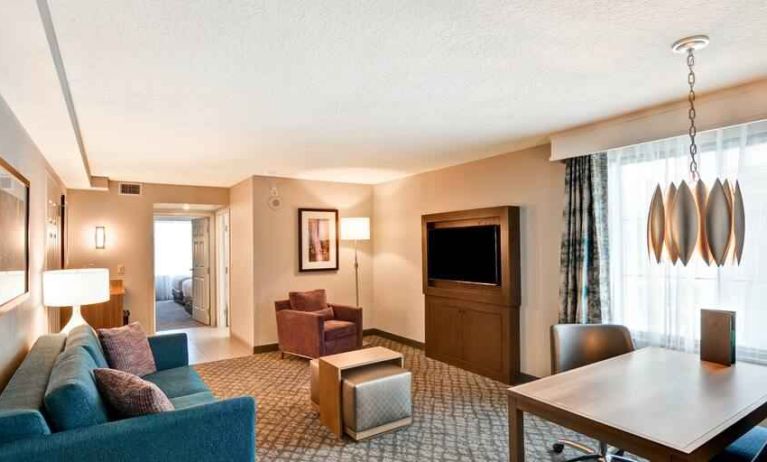 King executive room featuring living area, TV screen and sofa at the Embassy Suites by Hilton Orlando-Downtown.