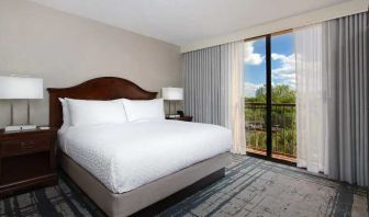 Bright king room with king bed and window at the Embassy Suites by Hilton Orlando International Drive Convention Center.