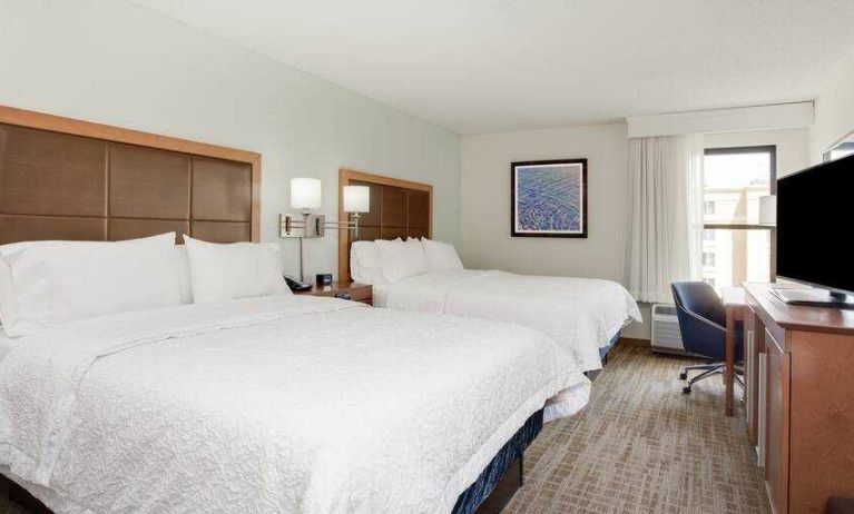 Hotel room with 2 queen size beds, TV screen and window at the Hampton Inn Orlando International Drive Convention Center.