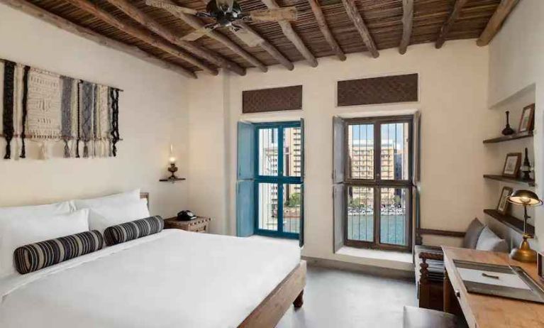 Bright room with king size bed, desk and windows at the Al Seef Heritage Hotel Dubai, Curio Collection by Hilton.