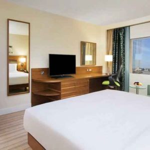 Comfortable queen room with window view and working desk at the Hilton Ras Al Khaimah Beach Resort.