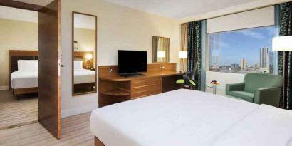 Comfortable queen room with window view and working desk at the Hilton Ras Al Khaimah Beach Resort.