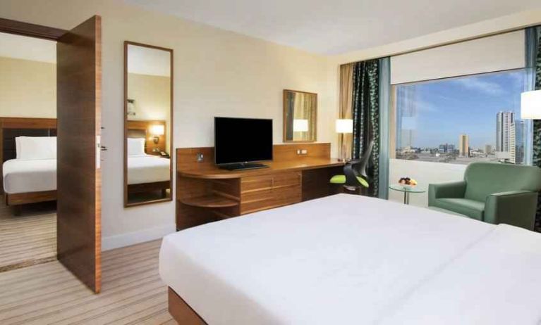 Comfortable queen room with window view and working desk at the Hilton Ras Al Khaimah Beach Resort.