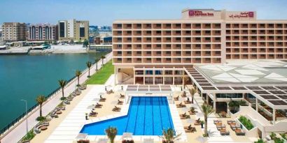 Relaxing outdoor pool area with outstanding creek view at the Hilton Ras Al Khaimah Beach Resort.