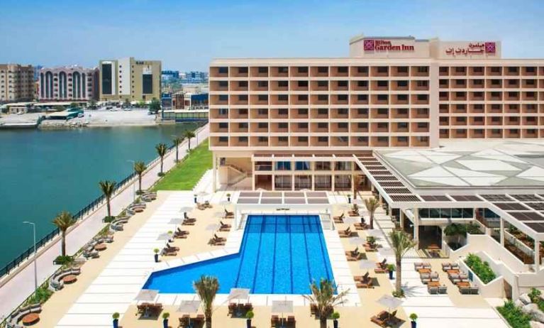 Relaxing outdoor pool area with outstanding creek view at the Hilton Ras Al Khaimah Beach Resort.