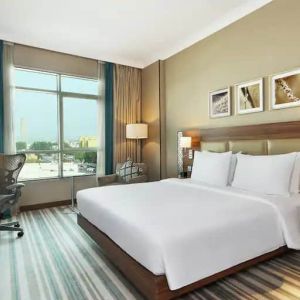 Comfortable King room with king bed, desk, tv and living room area at the Hilton Garden Inn Dubai Al Mina