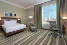 Large hotel room with king-size bed, great view of the city and spacious work area.