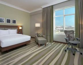 Large hotel room with king-size bed, great view of the city and spacious work area.