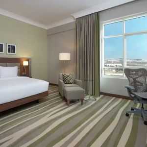 Large hotel room with king-size bed, great view of the city and spacious work area.