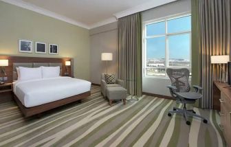 Large hotel room with king-size bed, great view of the city and spacious work area.