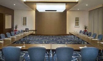 Spacious conference room with tables and chairs and a big wall for screenings at the Hilton Garden Inn Dubai Al Mina