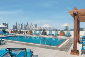 Beautiful outdoor pool with deck and pool chairs at the Hilton Garden Inn Dubai Al Mina