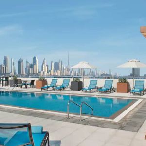 Beautiful outdoor pool with deck and pool chairs at the Hilton Garden Inn Dubai Al Mina