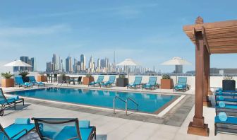 Beautiful outdoor pool with deck and pool chairs at the Hilton Garden Inn Dubai Al Mina