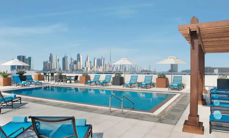 Beautiful outdoor pool with deck and pool chairs at the Hilton Garden Inn Dubai Al Mina