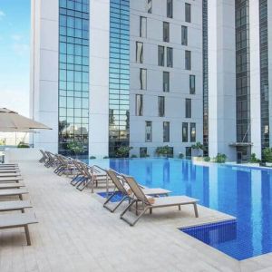 Beautiful outdoor pool with pool chairs at the Hampton Dubai Airport