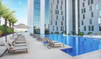 Beautiful outdoor pool with pool chairs at the Hampton Dubai Airport