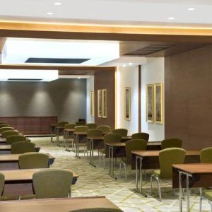 Large meeting room and workspace with multiple chairs and desks at the Hilton Garden Inn Dubai Al Muraqabat