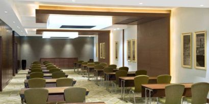 Large meeting room and workspace with multiple chairs and desks at the Hilton Garden Inn Dubai Al Muraqabat