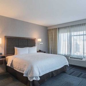 King bed with work desk and natural light at Hampton Inn Chicago North-Loyola Station.