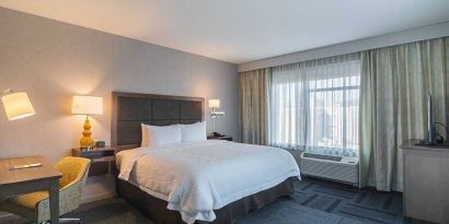 King bed with work desk and natural light at Hampton Inn Chicago North-Loyola Station.