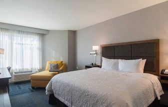 Spacious, king bed with natural light at Hampton Inn Chicago North-Loyola Station.