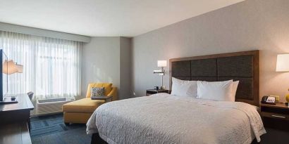 Spacious, king bed with natural light at Hampton Inn Chicago North-Loyola Station.