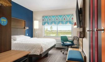 Clean king sized bed with TV and work area at Tru by Hilton Milwaukee Brookfield.