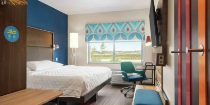 Clean king sized bed with TV and work area at Tru by Hilton Milwaukee Brookfield.