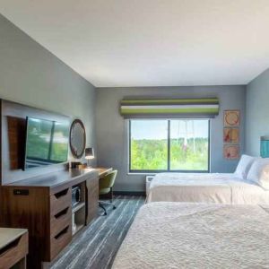 Double queen bedroom with desk, window and TV screen at the at the Hampton Inn Madison, OH.