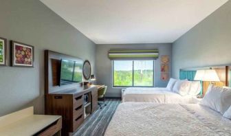 Double queen bedroom with desk, window and TV screen at the at the Hampton Inn Madison, OH.