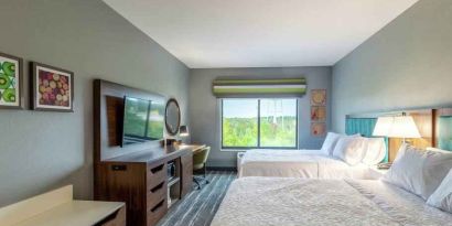 Double queen bedroom with desk, window and TV screen at the at the Hampton Inn Madison, OH.