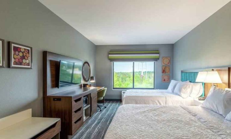 Double queen bedroom with desk, window and TV screen at the at the Hampton Inn Madison, OH.