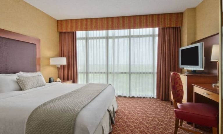 Spacious 2 bedroom suite with a king size bed, desk, tv, and bath at the Embassy Suite by Hilton Charlotte-Concord- Golf Resort & Spa.