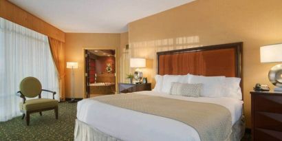 Spacious 2 bedroom suite with a king size bed, desk, tv, and bath at the Embassy Suites by Hilton Hampton Convention Center