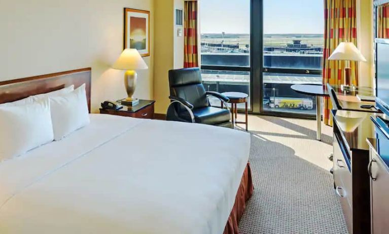 King size suite with king bed, sound proof windows, courch and a view of the runway at the Hilton Chicago O'Hare Airport