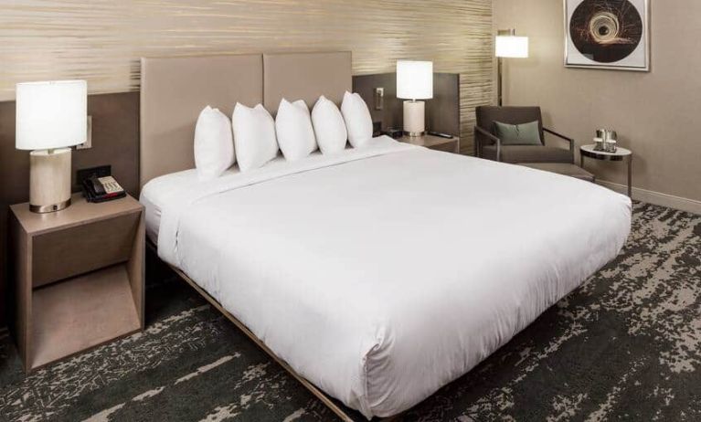 Spacious King suite with 1 king bed and chair at the DoubleTree by Hilton Boston Logan Airport Chelsea