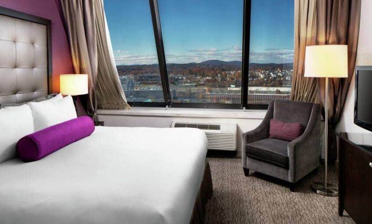 Spacious King suite with 1 king bed, chair and mountain view at the DoubleTree by Hilton Manchester Downtown