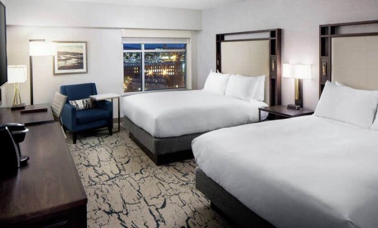 Spacious suite with 2 queen beds, chair, and tv at the DoubleTree by Hilton Manchester Downtown